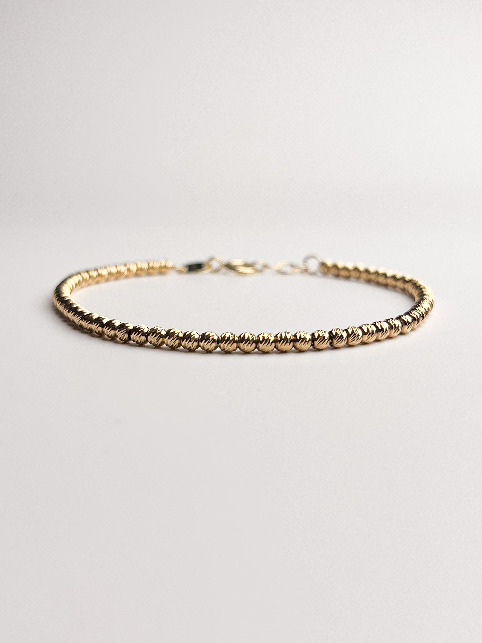 Gold bracelet on a light gray background