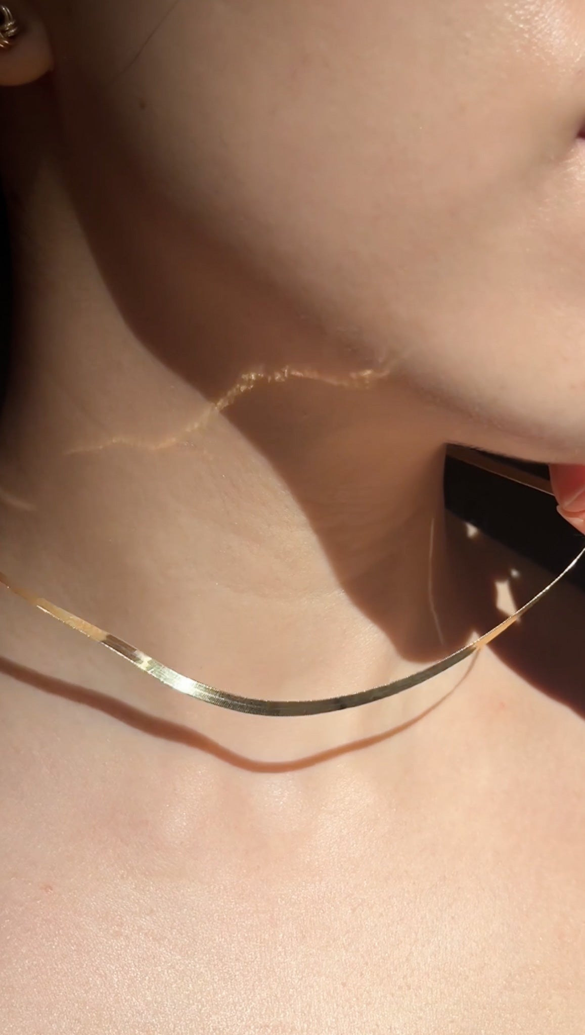 Close-up of our 18K solid gold snake chain in natural light